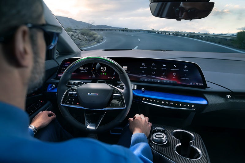 Front View of the 2026 OPTIQ-V Driving Through the Dusk Utilizing its Headlights | Bommarito Cadillac in Saint Peters MO